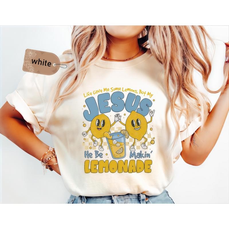 White T-Shirt with "Life Gave Me Some Lemons, But My JESUS He Be Makin' LEMONADE" Print in Blue and Yellow, Featuring...